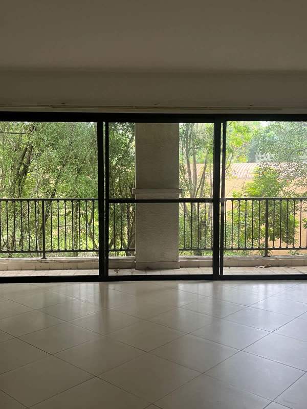Spacious living room large glass doors to balcony forest views Embassy Club Clayton Panama
