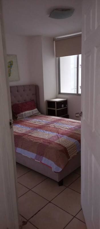 Small modern bedroom with tufted bed patterned quilt tile floor window in PH Vista Tower Panama