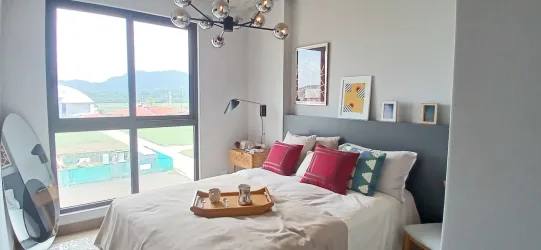 Open social space at PH Centriqo with dining tables, bar counter and greenery in Panama Pacifico