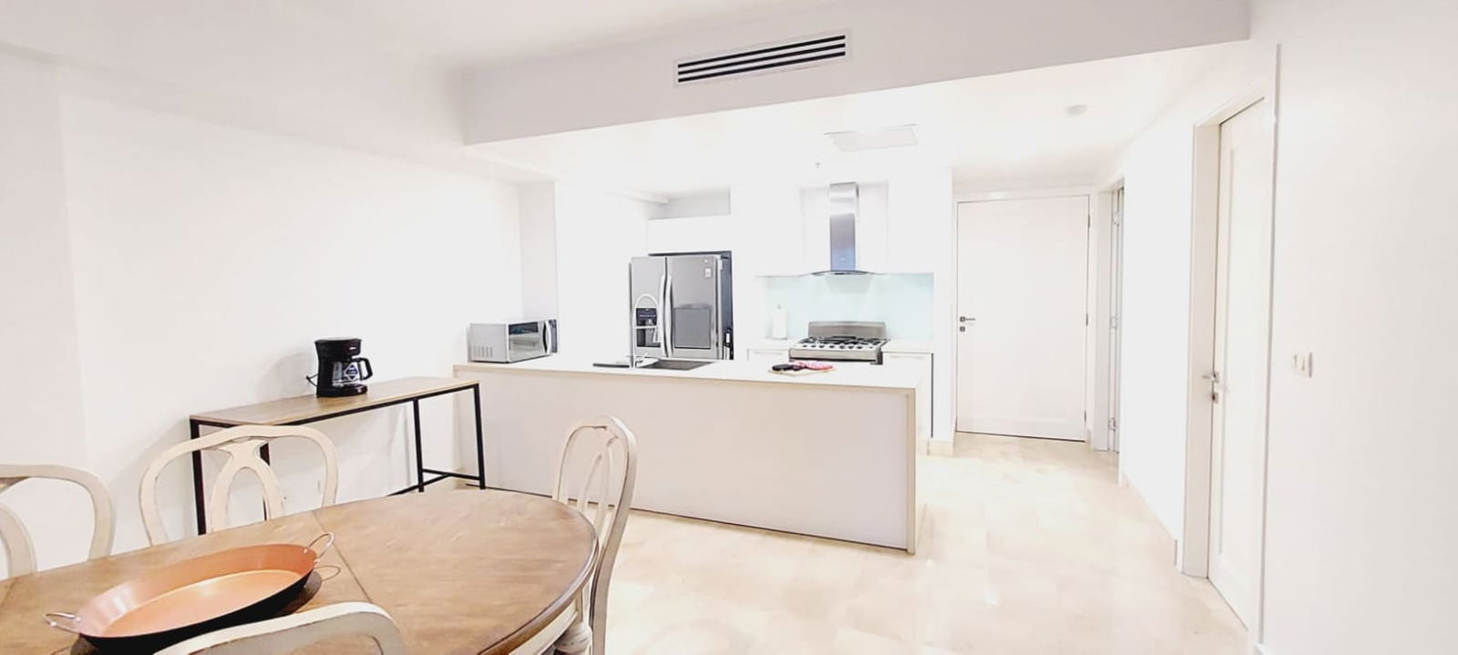 Bright open kitchen with island and dining area luxury rental Panama City