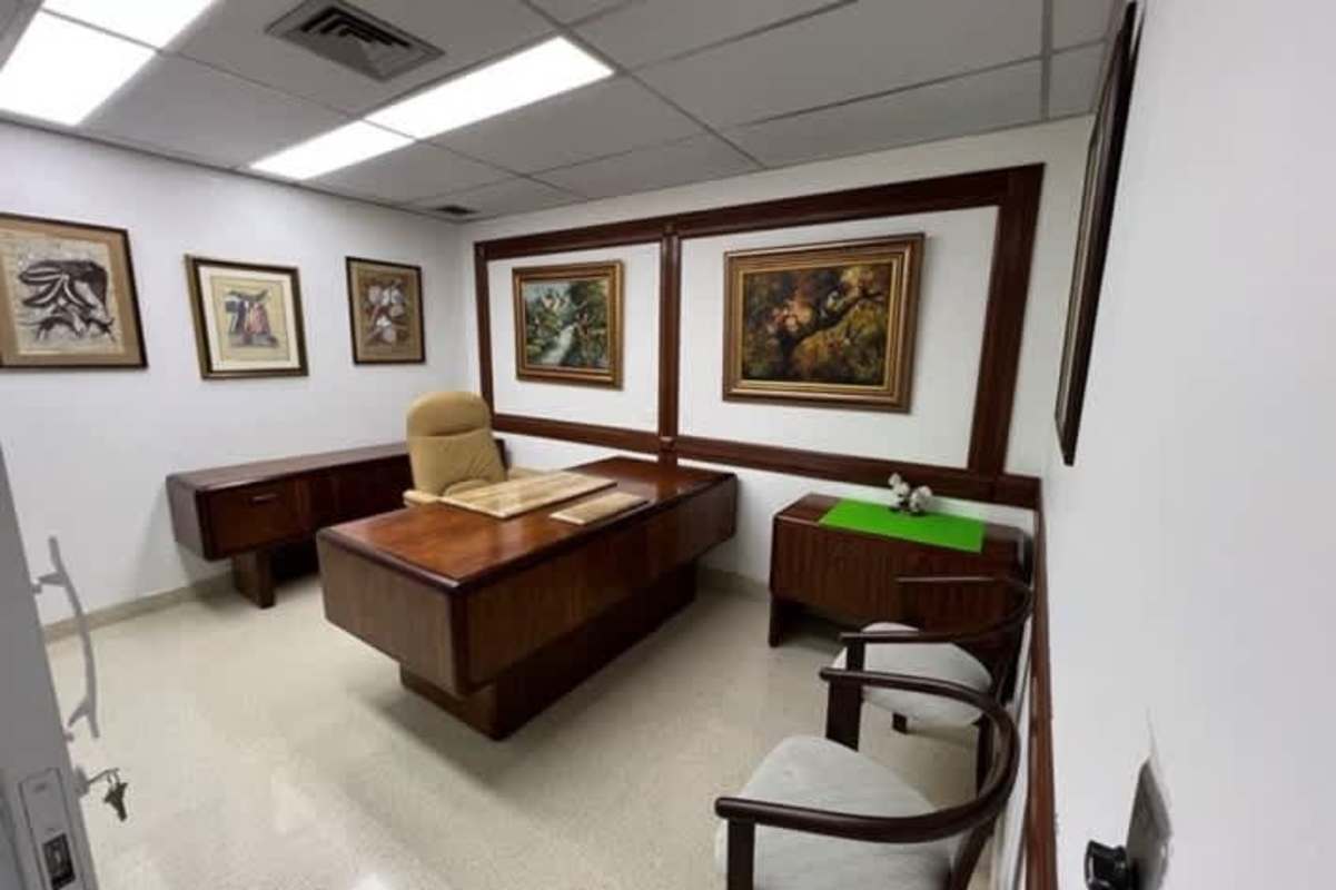 Doctor's consultation room with wood trim, artwork, and classic furnishing in Panama