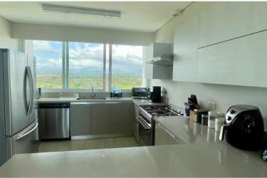 Sunlit kitchen with granite countertops and modern appliances in PH Punta Barco Village