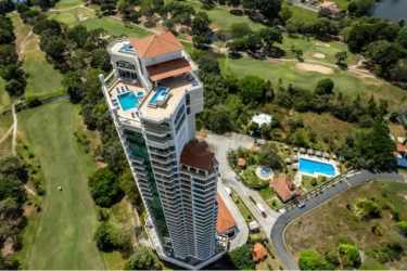 Aerial view modern high-rise Coronado Golf Tower with rooftop pool oceanfront golf course Panama