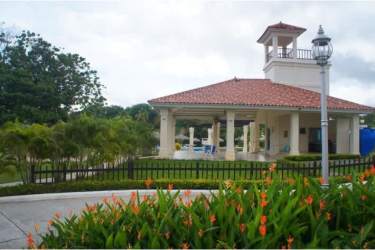 Elegant pavilion with red-tiled roof surrounded by gardens and black metal fence at Coronado Golf Tower Panama