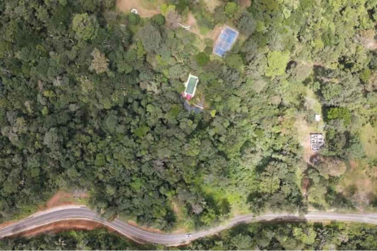 Aerial view forested estate with tennis court, pool, clearings inside Altos de Pacora Panama