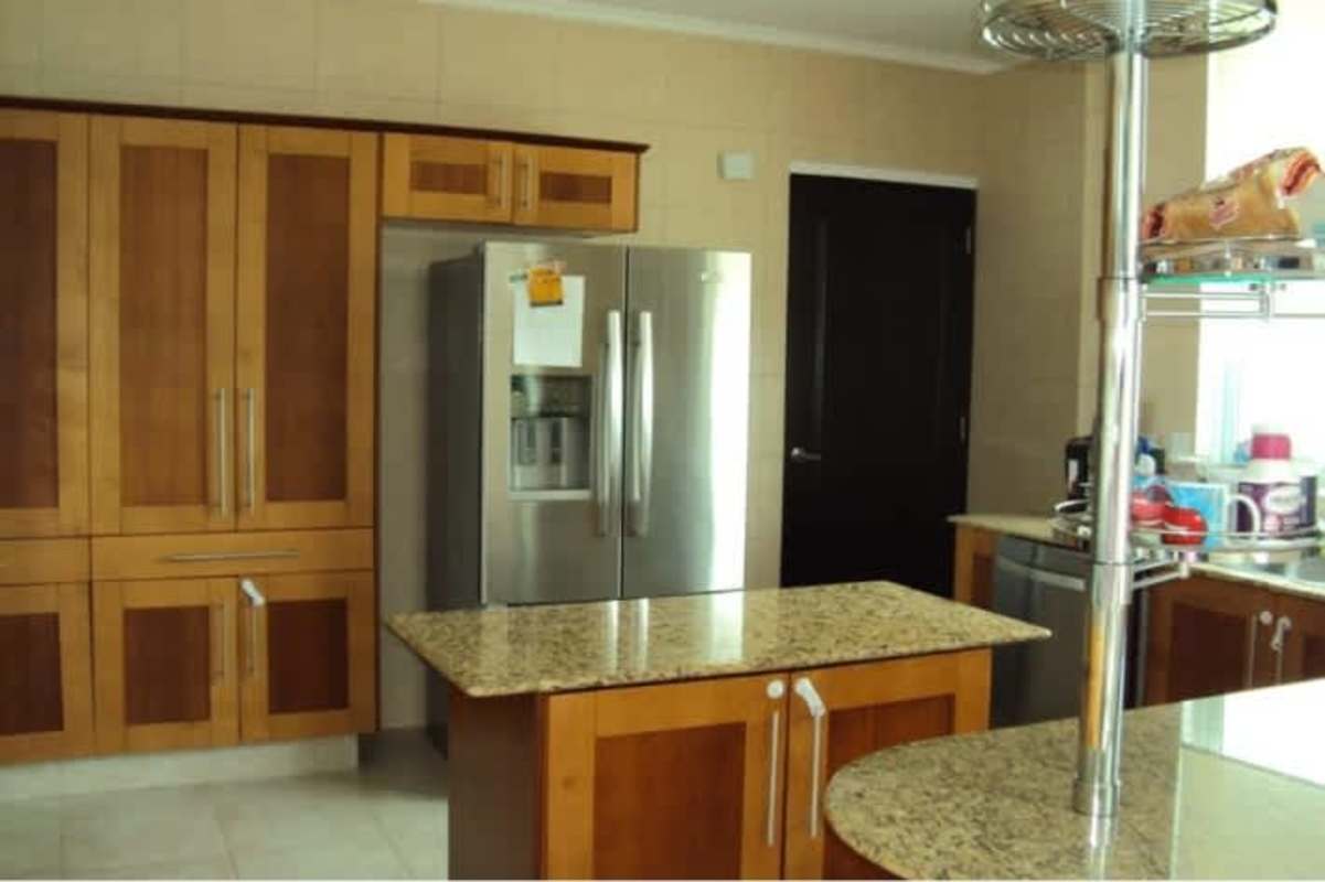 Modern kitchen with granite countertops, stainless steel refrigerator, island and wooden cabinetry Ocean Two Punta Pacifica Panama