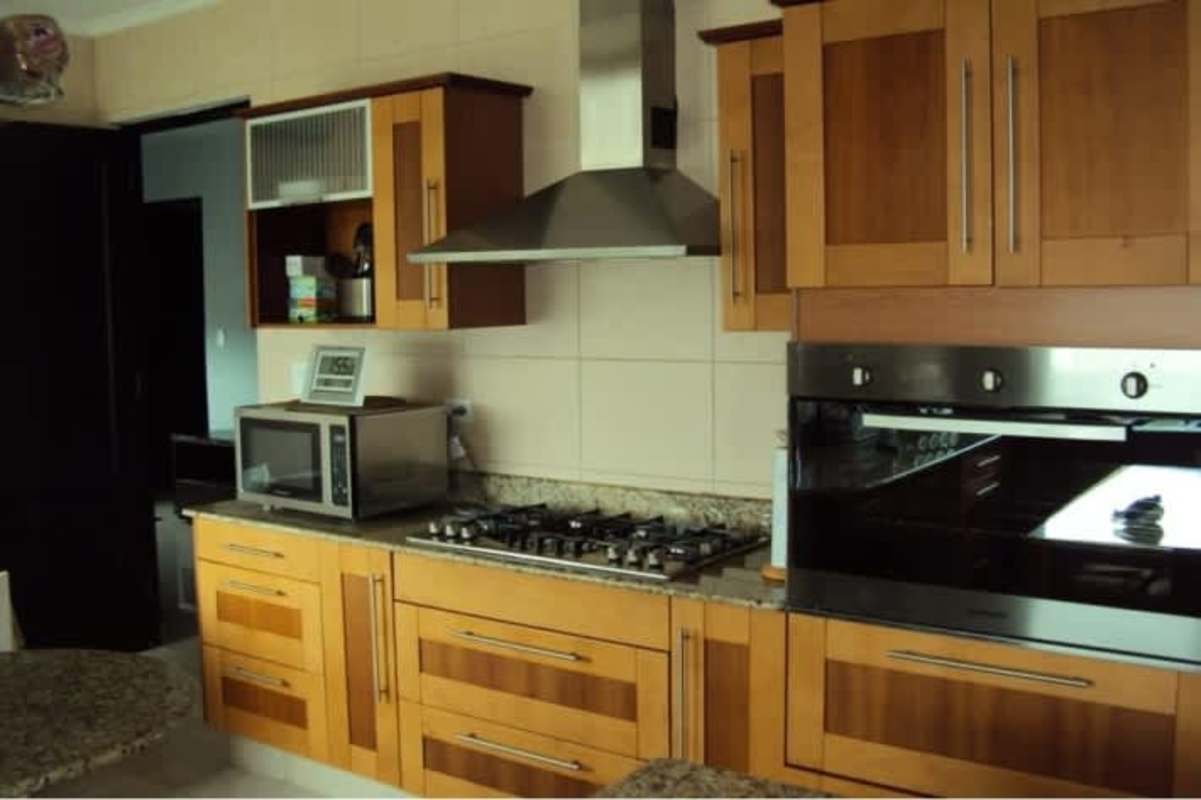 Fully equipped modern kitchen with wood cabinetry, granite counters and built-in appliances in Ocean Two Panama City