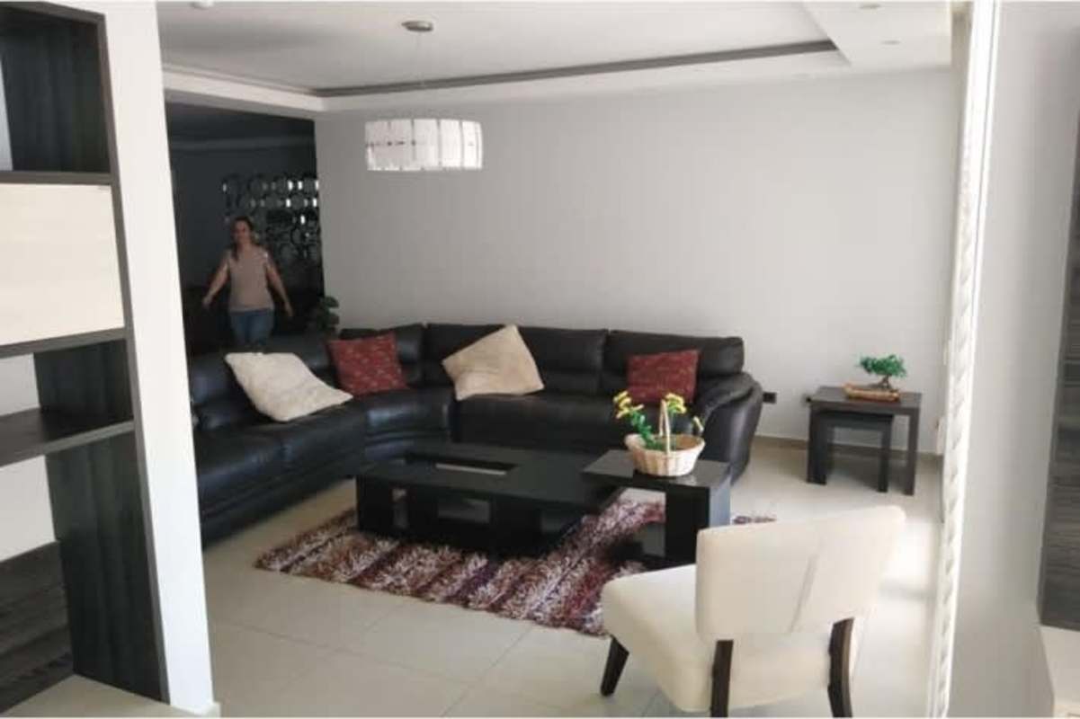 Dining room featuring large mirror, dark wooden dining table and stylish pendant lamp in Ocean Two Punta Pacifica apartment
