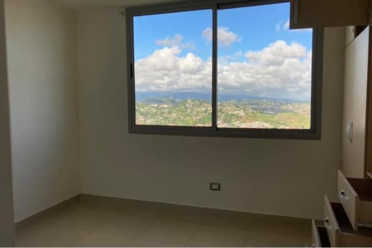 Minimalist bedroom with large window offering city and landscape views in PH Rokas Condado del Rey