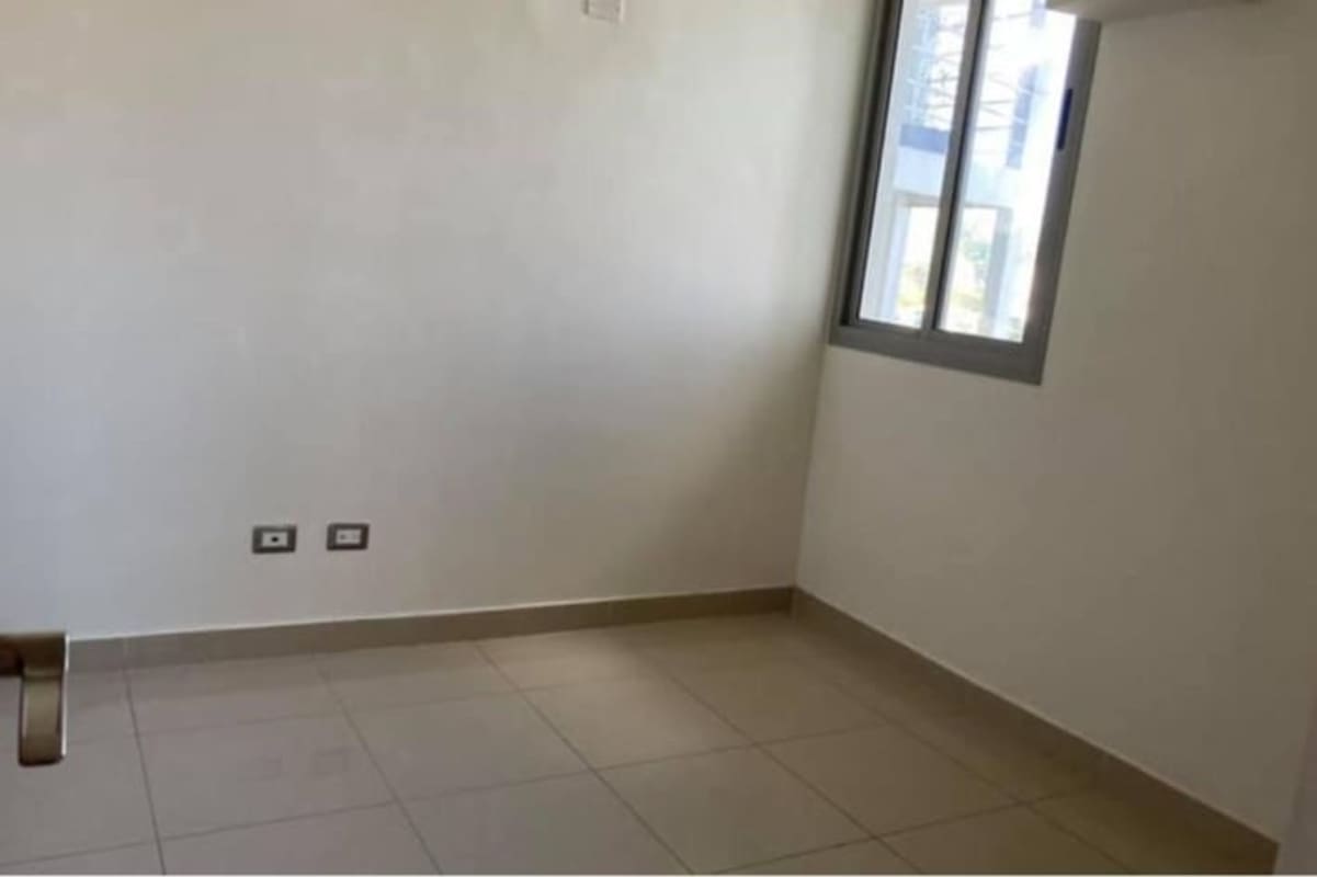 Unfurnished bedroom with tile floor, white walls and window with neighborhood views in PH Rokas Panama