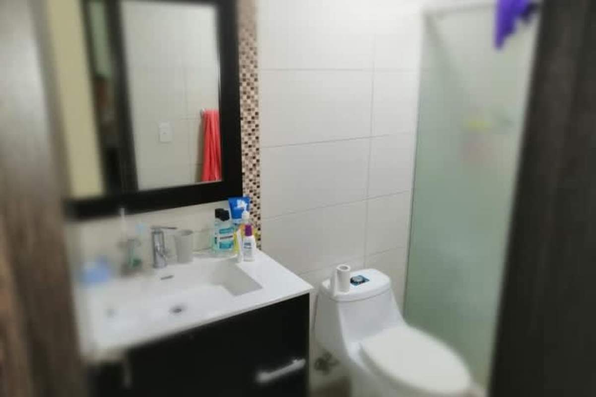 Bathroom with glass shower enclosure, tile accent strip PH King's Park Panama