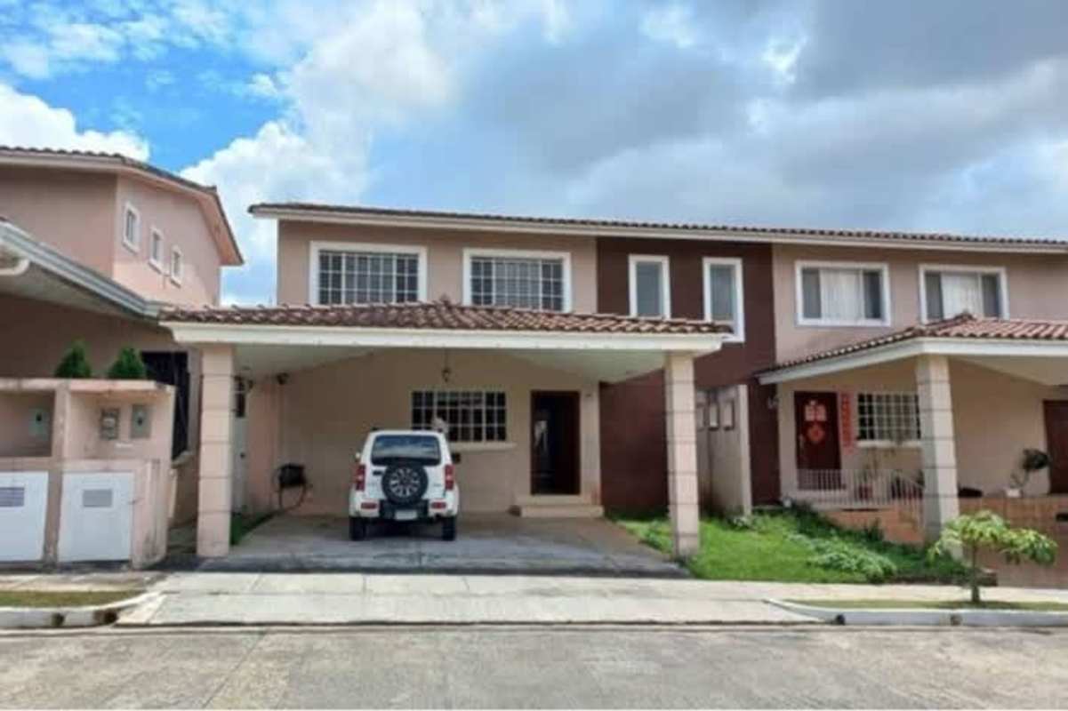 Street view of two-story villa with carport and driveway at PH Villa Tiber Brisas del Golf Panama