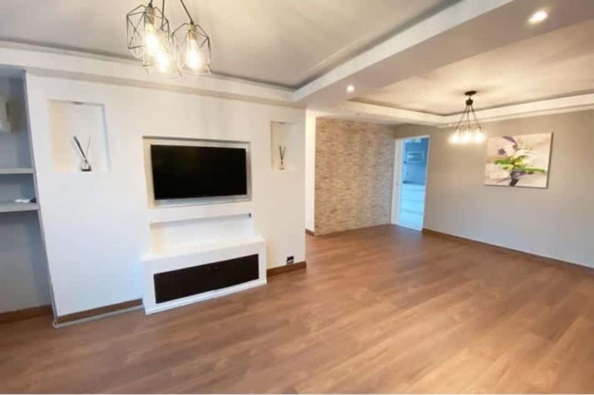 Living-dining space with stone accent walls, designer ceiling lights in PH San Francisco Park Tower Panama