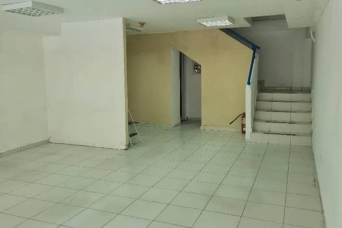 Commercial unit interior with ceramic floors, stairs with blue railing, open plan design in El Cangrejo Panama
