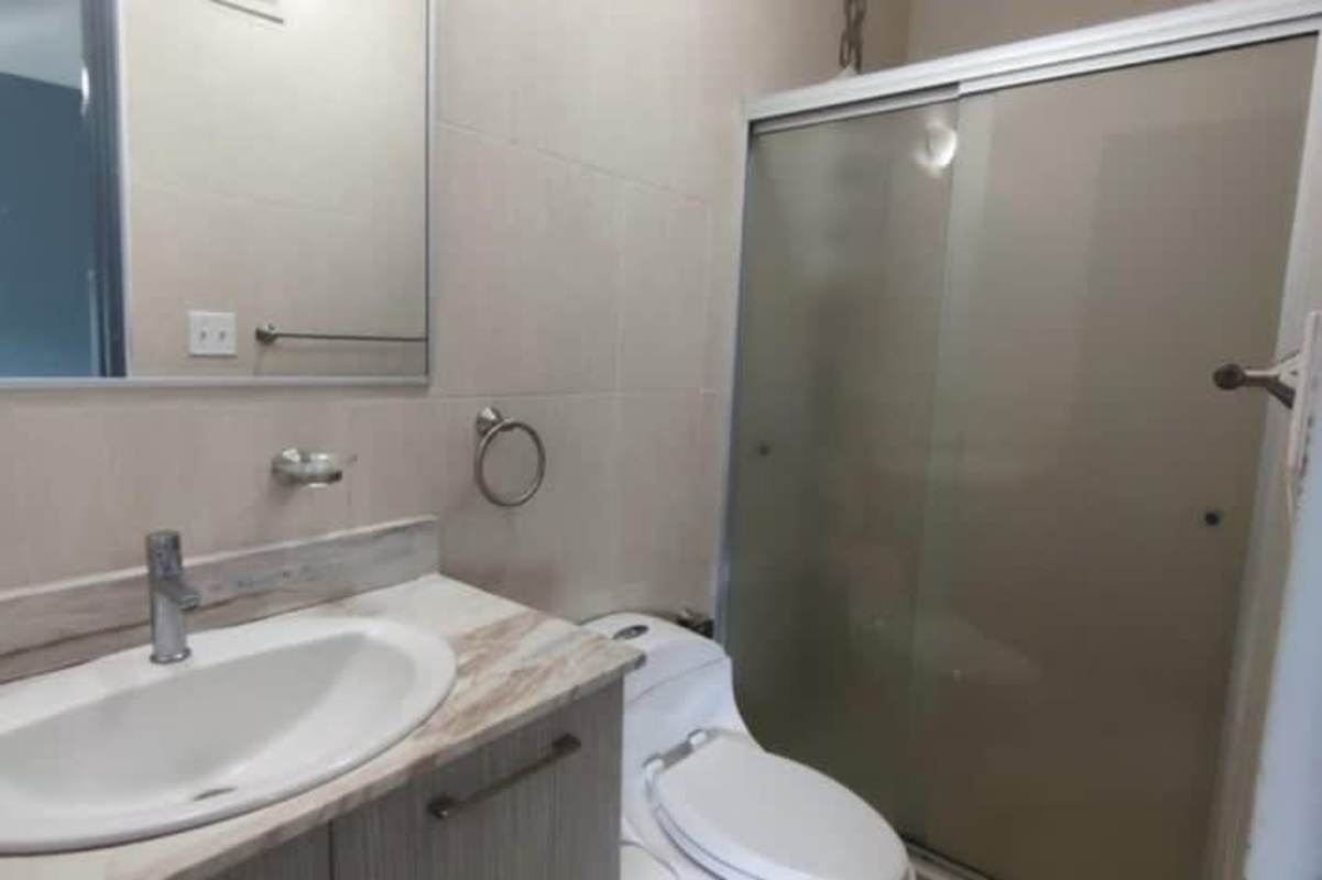 Contemporary kitchen with double sink and black granite counters at Condado Country Club apartment Panama
