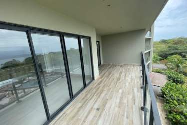 Bright bedroom with window showcasing panoramic Pacific views in Solaria Punta Caelo Panama