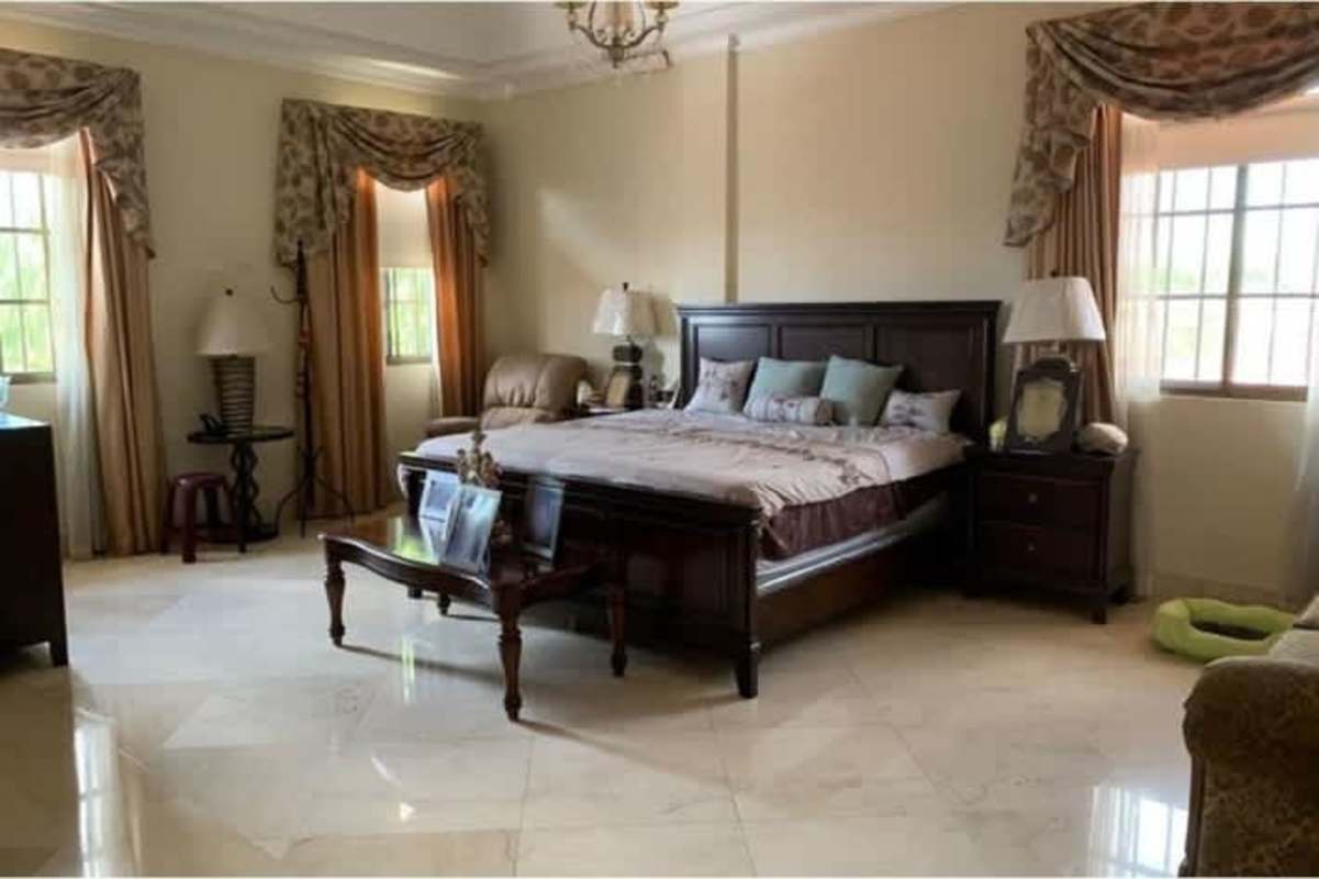 Large master bedroom with marble flooring and classic decor in luxury house Chanis Panama City