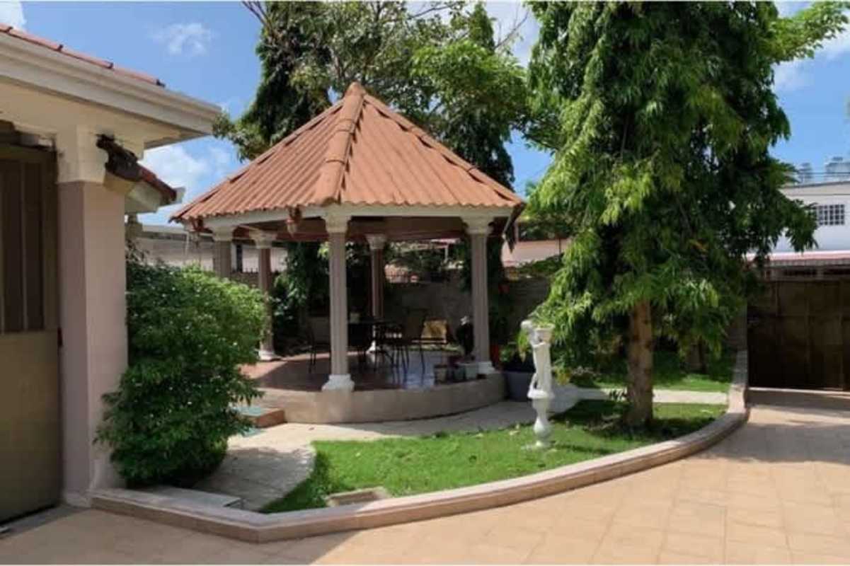 Spacious walk-in closet with wooden shelving and arched natural light window in Chanis Parque Lefevre house