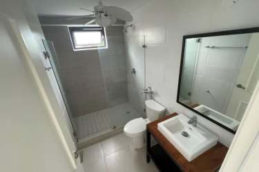 Minimalist condo bathroom with walk-in glass shower PH Solaria Punta Caelo Panama