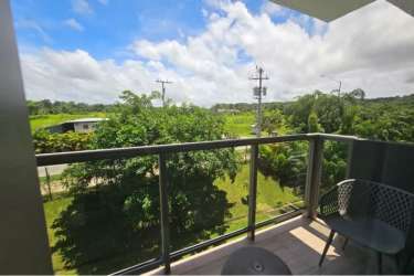 Open plan living room and dining with light decor and garden view balcony in Panama Pacifico