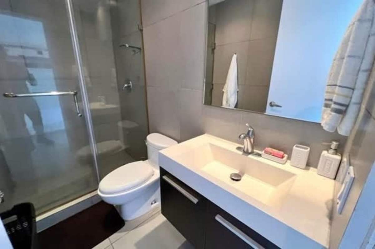 Contemporary bathroom with glass shower, white bathtub, double sink vanity in PH BICSA financial center Panama