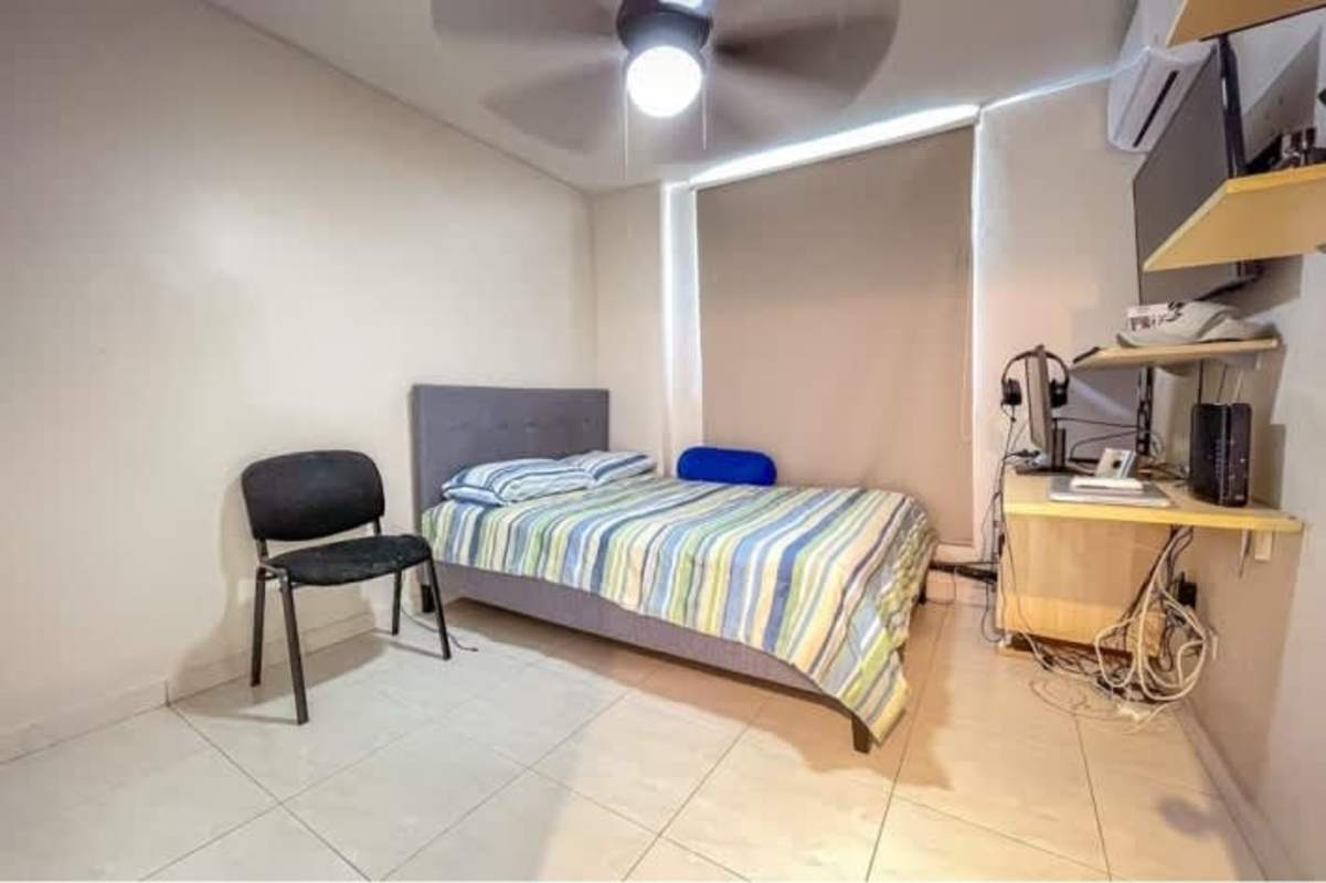 Bright bedroom with built-in wardrobe tile flooring ceiling fan in Condado del Rey Panama