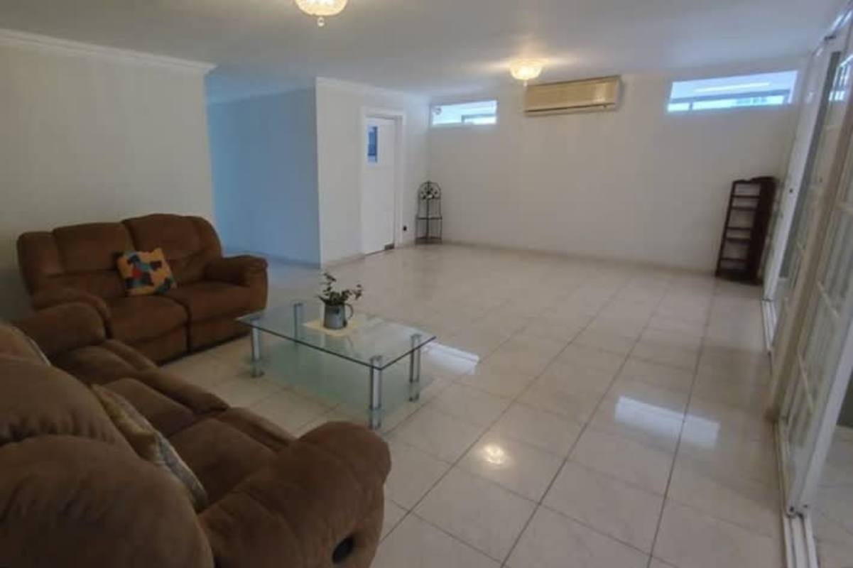 Kitchen with blue cabinets, tile floors, dining area in El Cangrejo Panama City house