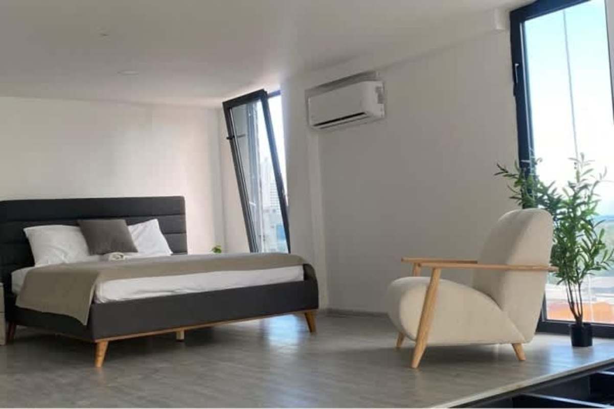 Minimalist loft bedroom with city view and large windows in PH San Francisco Loft Panama