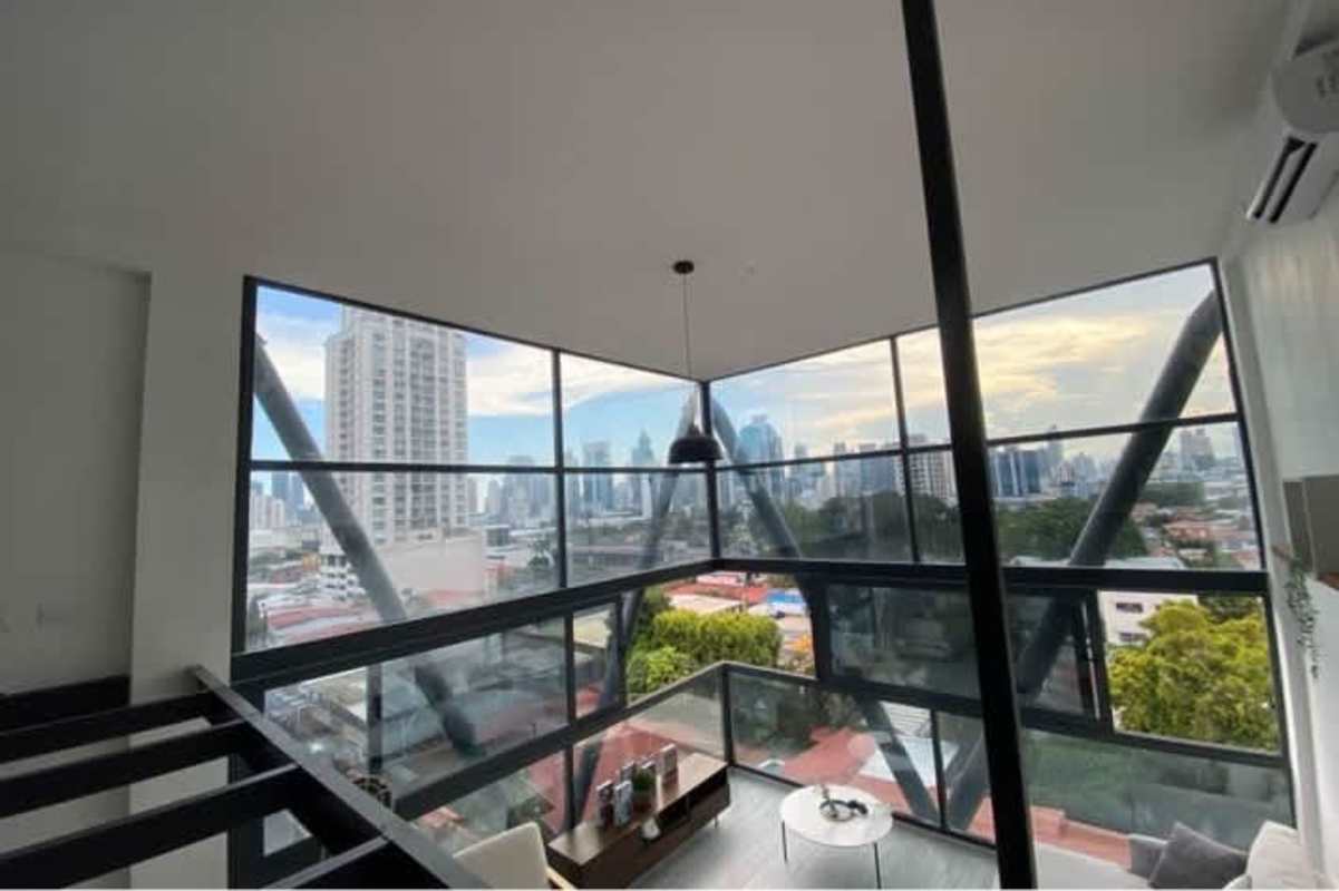 Open loft bedroom with panoramic windows and skyline view PH San Francisco Loft Panama City