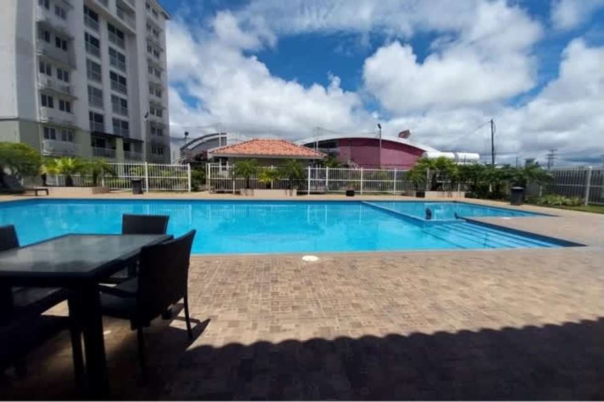 Large outdoor swimming pool with seating and landscaping at PH Versalles