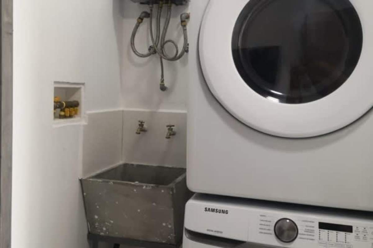 Laundry area with stacked washer and dryer inside apartment at PH The Gray Panama City