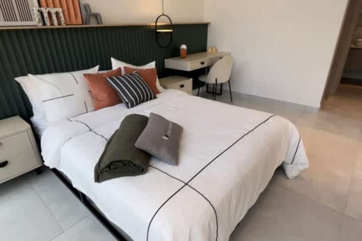 Bedroom with padded headboard, desk setup, accent wall and modern furnishings PH Arcadia Costa del Este Panama