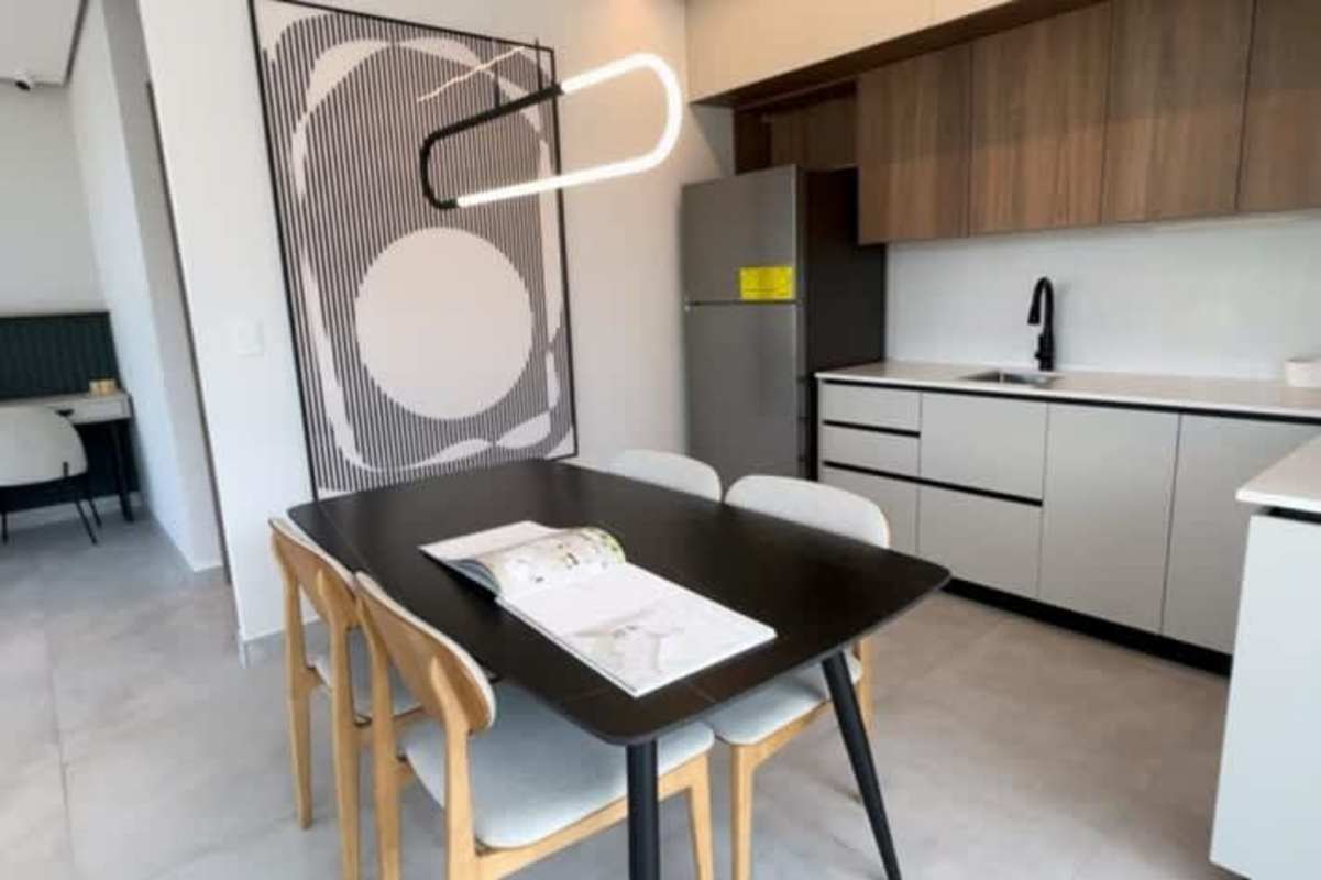 Open plan kitchen dining with sleek cabinets, black dining table, light wood accents at PH Arcadia Panama