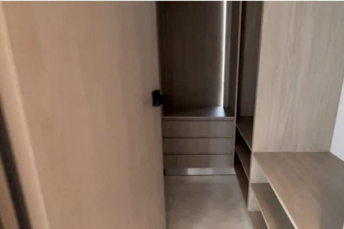 Modern minimalist walk-in closet with built-in wood cabinetry at PH Arcadia Costa del Este Panama