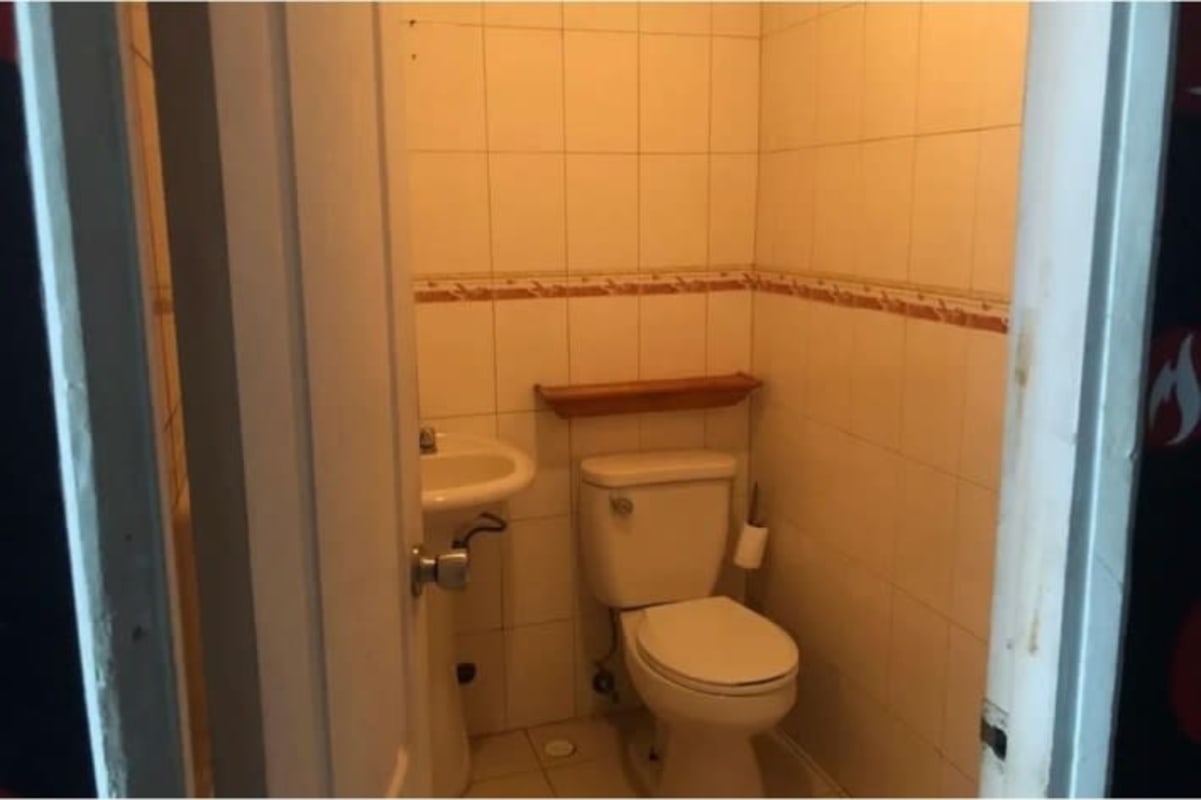 Commercial bathroom with pedestal sink and tiled walls for retail space PH H2O Panama