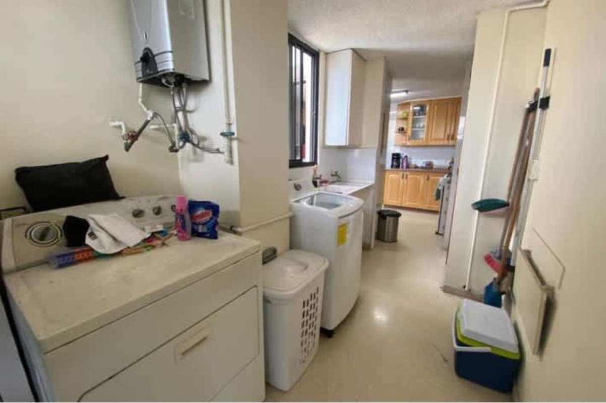 Traditional kitchen with wood cabinets, gas stove, double sink, large window and appliances Panama