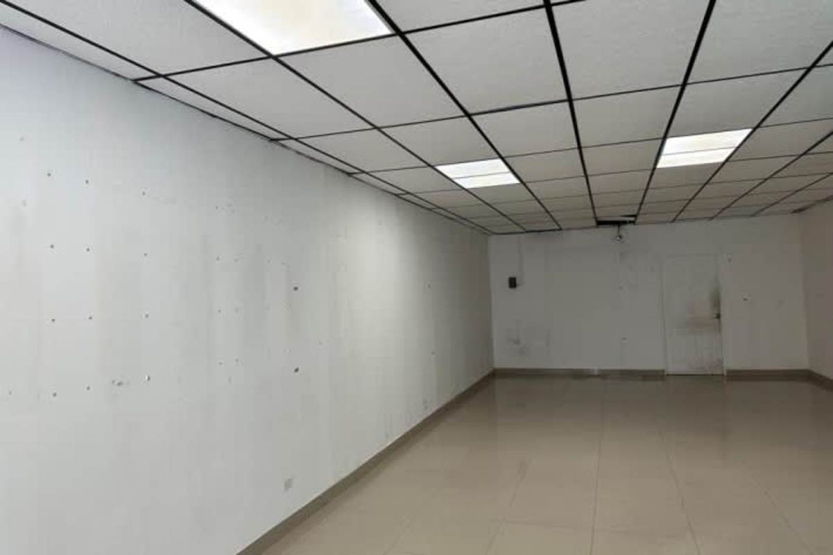 Vacant commercial retail space with tiled floors, drop ceiling, large glass windows in Plaza Inca Panama City