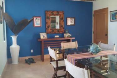 Dining area with blue accent wall, glass table near terrace Buenaventura Panama