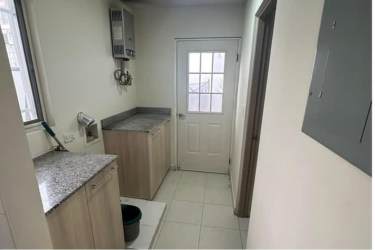 Closed modern kitchen with window, wood cabinetry and granite-style countertop