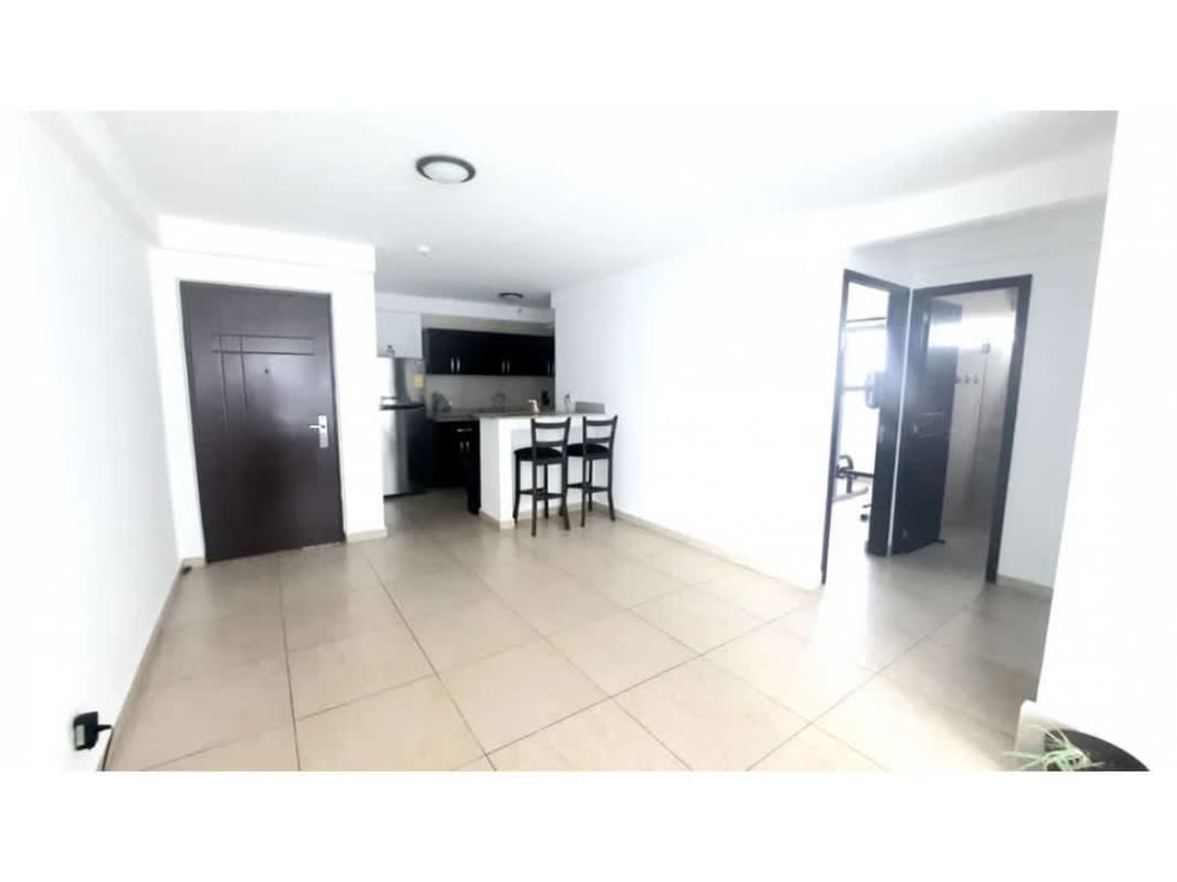 Kitchen in PH Torre 100 featuring granite countertop, dark wood cabinets, stainless fridge and breakfast bar Carrasquilla Panama