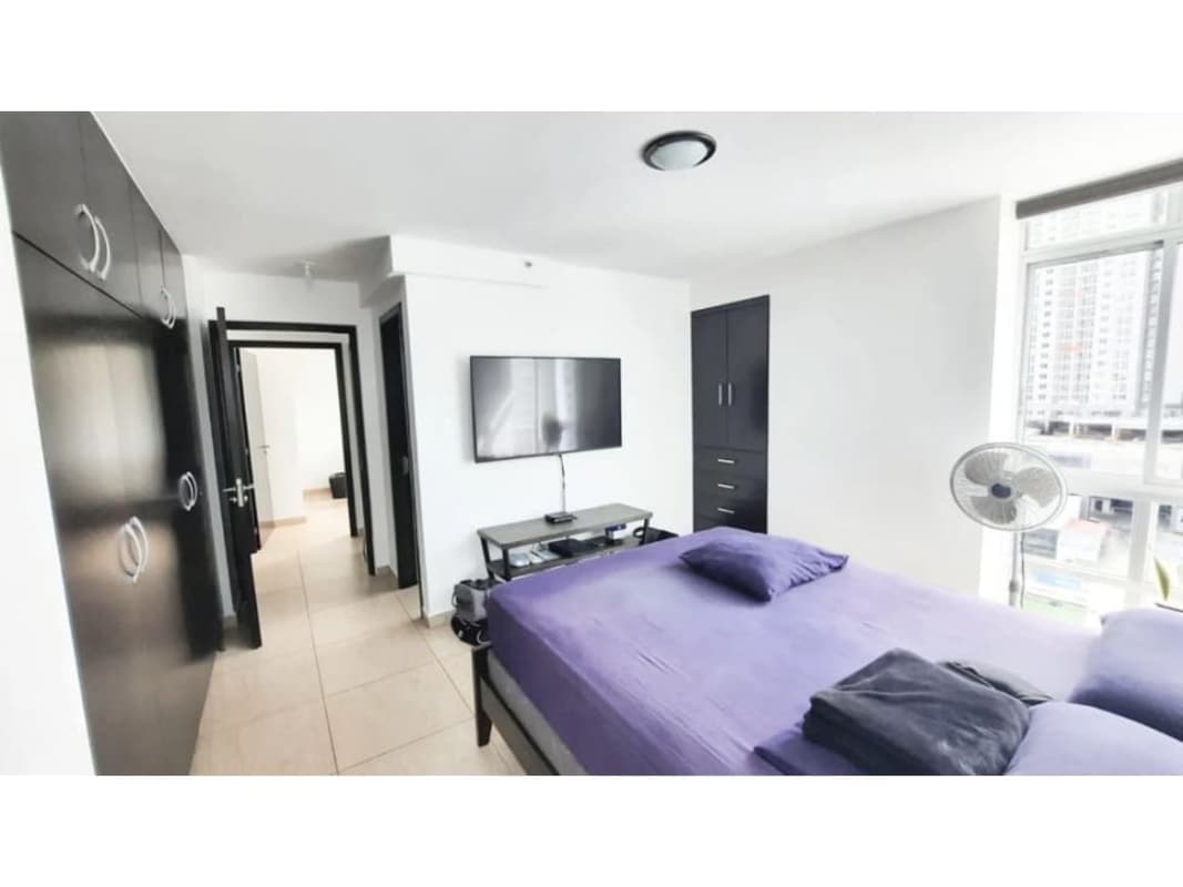 Modern bedroom with corner windows, tile floors, purple bedding and wardrobe in PH Torre 100 Panama