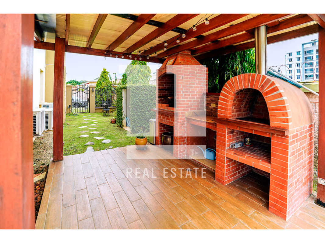 Modern living and dining area with red wall, tile flooring in Altos de Panamá Residence