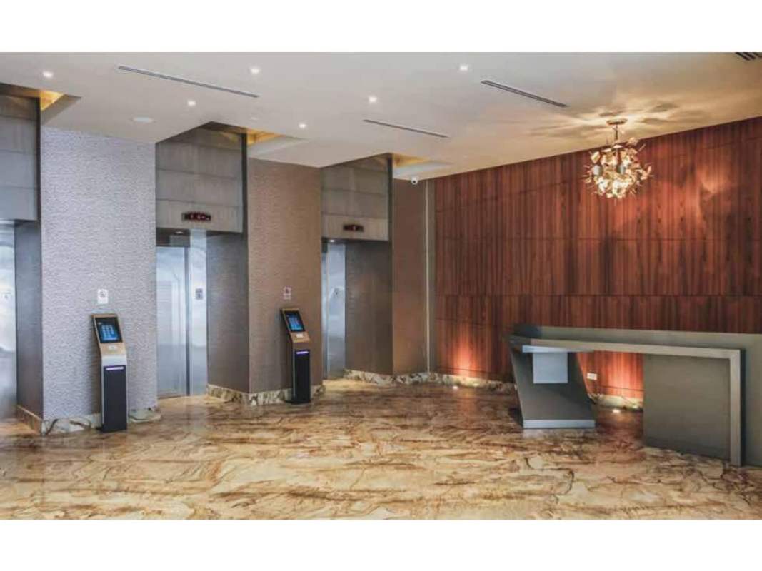 Luxury lobby with marble floor, wood paneling, reception and elevators at PH BICSA