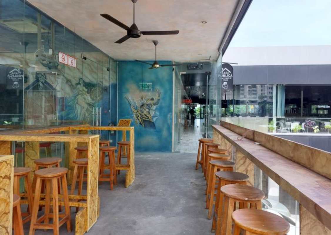 Modern cafe interior with murals, wood beams, glass walls, and high seating in Balboa Boutiques Plaza Panama