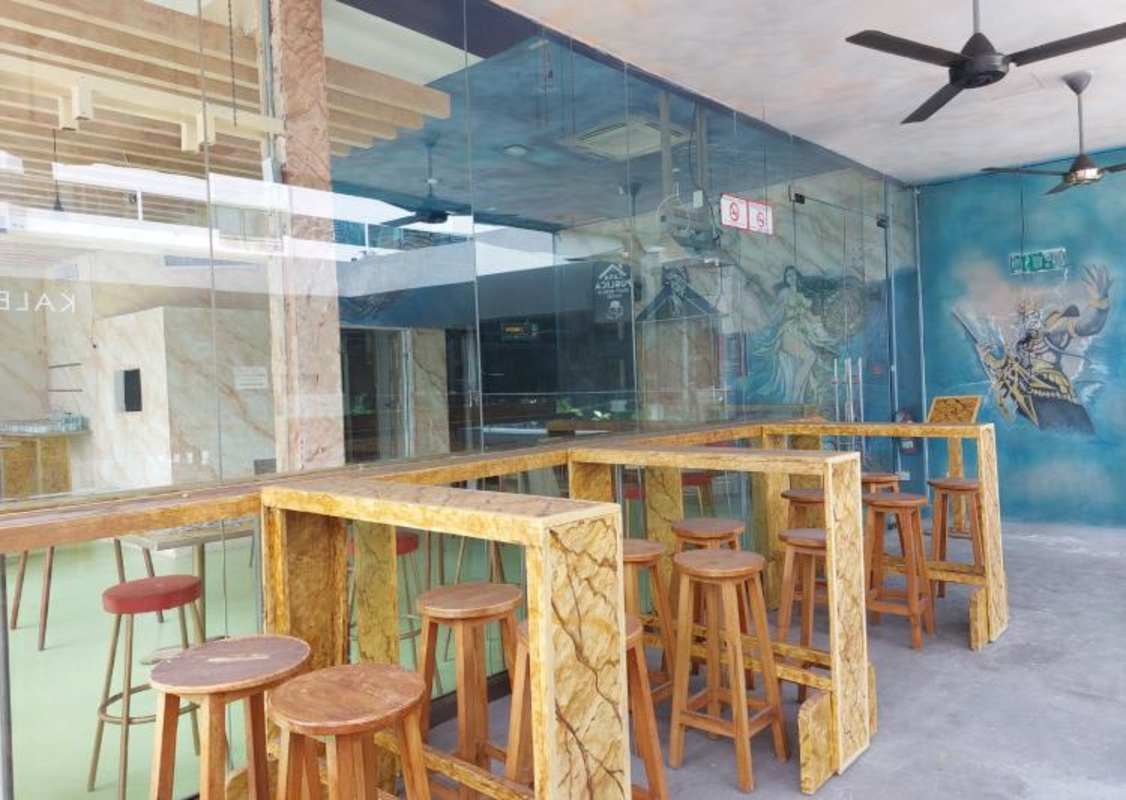 Restaurant space with marble walls, murals, bar counter and pendant lighting at Balboa Boutiques Panama