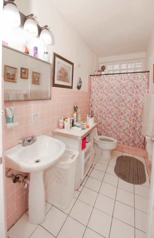 Classic bathroom featuring pink tile design, white pedestal sink, floral shower curtain, PH Majurova Panama City