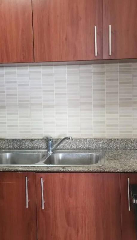 Kitchen with granite countertop, stainless sink and wooden cabinets in PH San Francisco Bay Apartment Panama City