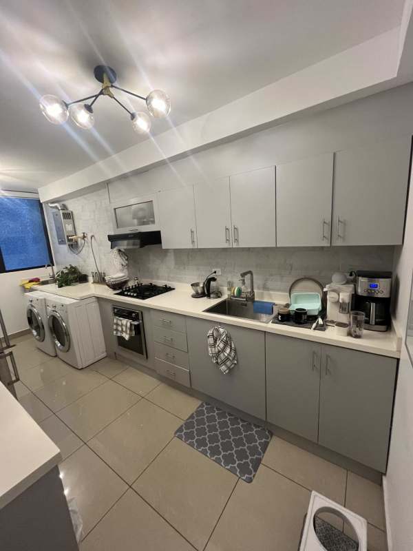 Kitchen with gray cabinetry, built-in appliances quartz countertops at PH San Francisco Bay