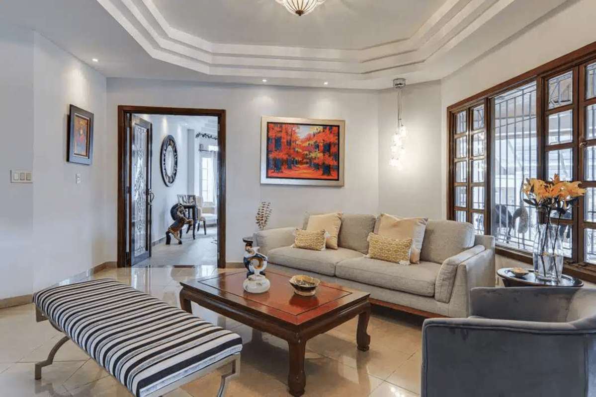 Spacious living room with tray ceiling, large windows, and garden views in house for sale Dos Mares Panama