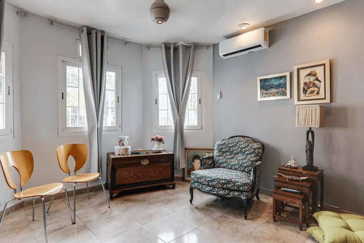 Large covered terrace with ceiling fan, seating area and view of private pool and garden in house Panama City